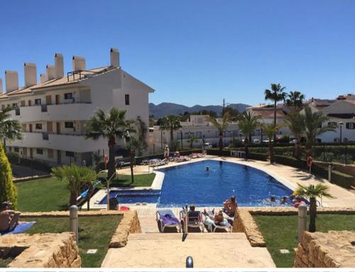 uma grande piscina com pessoas num resort em Apartamento Alfaz Del Sol em L'Alfàs del Pi
