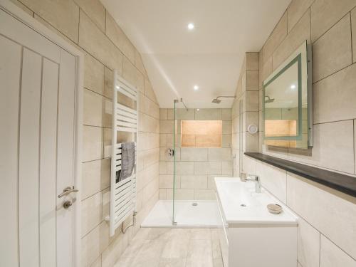 een witte badkamer met een wastafel en een douche bij Beech Cottage - Uk11845 in Saltash