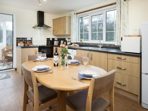 cocina con mesa de madera con sillas y comedor en Dunstanburgh View, en Craster