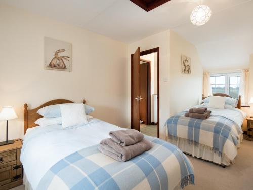 1 dormitorio con 2 camas y toallas. en Dunstanburgh View, en Craster