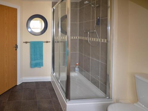 een badkamer met een douche met een glazen achterdeur bij The Costal Hideaway in Sidmouth