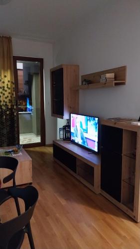 sala de estar con TV de pantalla plana en un centro de entretenimiento en F&M Apartment No 12, en Skopje