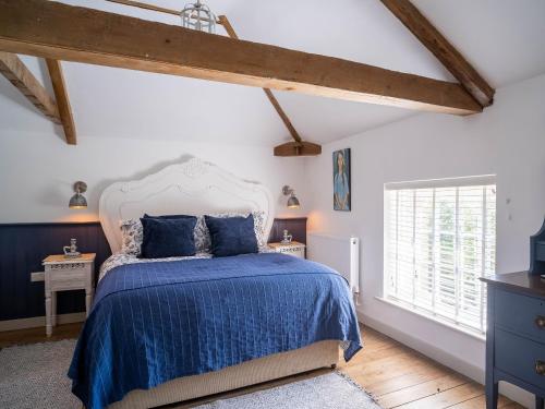 a bedroom with a blue bed and a window at Tack Room in Benniworth