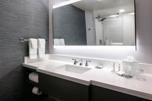 a bathroom with a sink and a large mirror at West Des Moines Marriott in West Des Moines