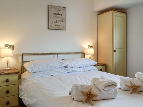 1 dormitorio con 1 cama con toallas en Pennti Treth - Uk39455, en Saint Columb Minor