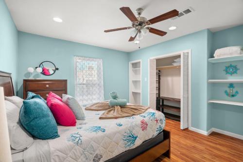 a bedroom with a bed with a ceiling fan at Serene Beachside Getaway - 77 Steps To The Ocean in Galveston