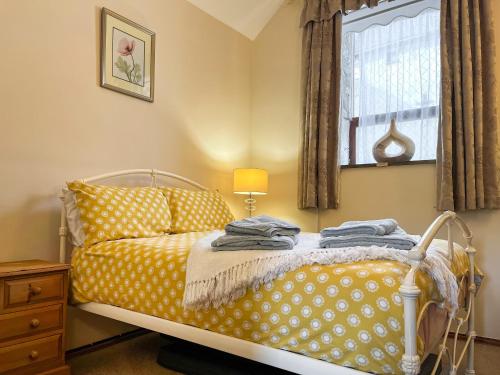 a bedroom with a bed with yellow and white polka dots at Ravenscliffe Cottage in Tissington