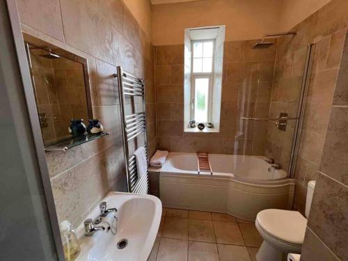 克里安拉利的住宿－Scottish Highland Cottage Tyndrum Upper Station，带浴缸、盥洗盆和卫生间的浴室