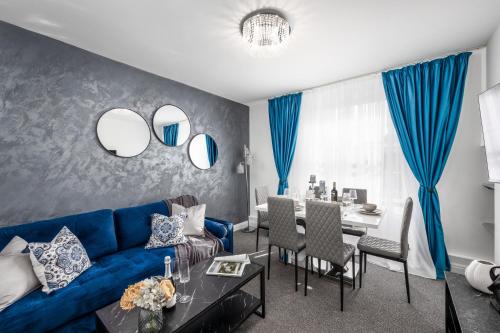 ein Wohnzimmer mit einem blauen Sofa und einem Tisch in der Unterkunft Cosy 4-Bedroom Apartment next to Borough in London