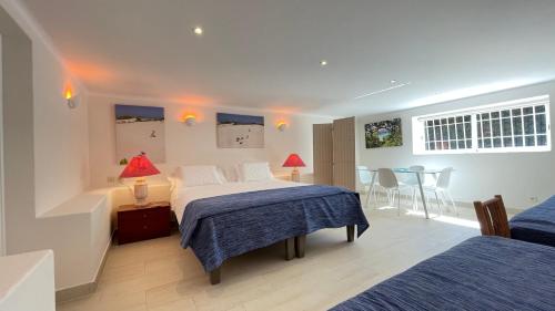 a bedroom with two beds and a table and chairs at Studio with Private Swimming Pool and Garden in Cascais