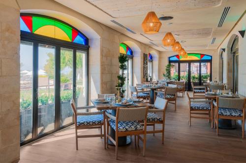 a restaurant with tables and chairs with stained glass windows at Dead Sea Marriott Resort & Spa in Sowayma