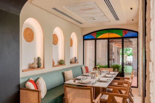a dining room with a table and chairs and a stained glass window at Dead Sea Marriott Resort & Spa in Sowayma