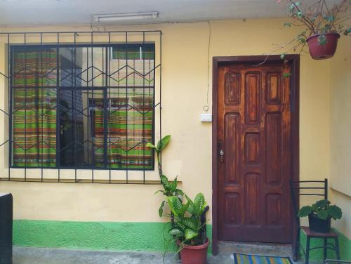 uma casa com uma porta de madeira e uma janela em Villa bonita em Baños