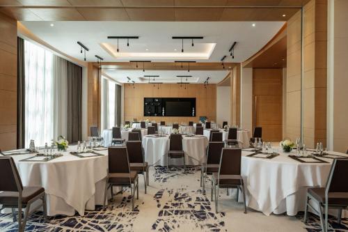 a conference room with tables and chairs and a screen at Le Royal Méridien Place Vendôme Lusail in Doha