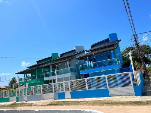 niebiesko-zielony budynek po stronie ulicy w obiekcie Privê Shalom w mieście Tamandaré