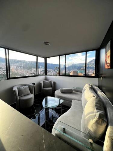 - un salon avec des canapés, une table et des fenêtres dans l'établissement penthouse con una vista perfecta, à Bello
