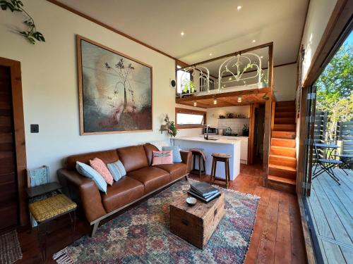 a living room with a couch and a kitchen at Te Awa Mata o' Tukituki in Havelock North