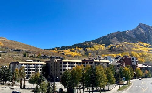a city with buildings and trees and a mountain at MT CB Base Area with King Bed, Outdoor Hot Tub & Pool in Crested Butte