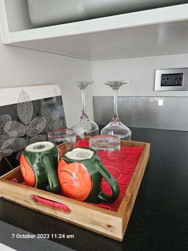 a wooden tray with glasses and wine glasses at House on the Hill in New Plymouth