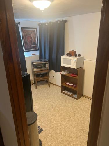 a room with a living room with a microwave and a computer at Anthony's Home in Spokane