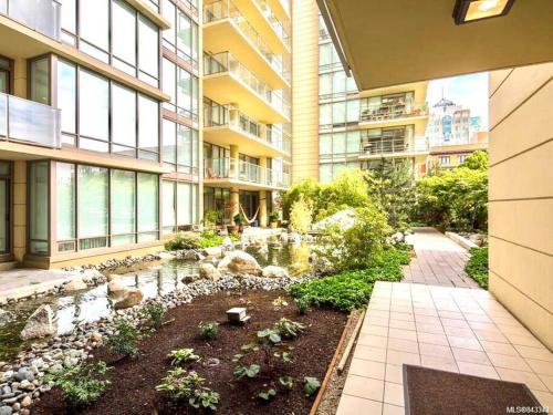 a garden in the middle of a building with a pond at Waterfalls Hotel in Downtown With Stunning Views! in Victoria