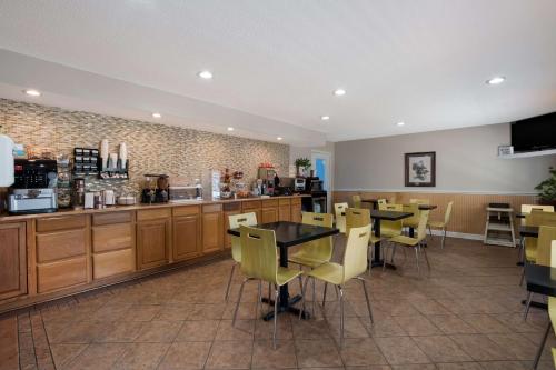 a restaurant with tables and chairs and a counter at SureStay Hotel by Best Western Manning in Manning