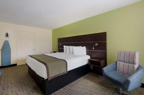 a hotel room with a bed and a chair at SureStay Hotel by Best Western Manning in Manning