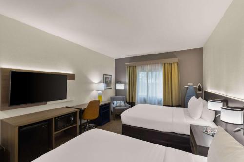 um quarto de hotel com duas camas e uma televisão de ecrã plano em Comfort Inn & Suites ATX North em Austin