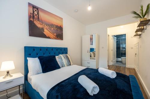1 dormitorio con cama azul y almohadas blancas en Stunning 2 Bedroom Apartment in Chorlton, en Mánchester