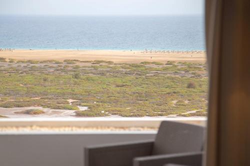 een raam met uitzicht op het strand bij The Sunny Flair, Relaxing Experience in Morro del Jable