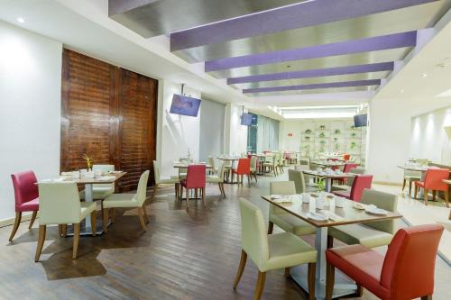 a dining room with tables and chairs and purple ceilings at Real Inn Ciudad Juarez by the USA Consulate in Ciudad Juárez