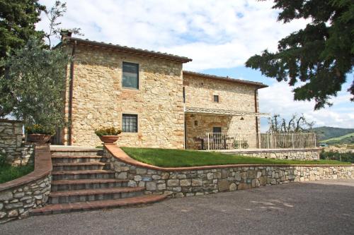 Casa de piedra con pared de piedra y escaleras en AGRITURISMO VICOLABATE en San Casciano in Val di Pesa