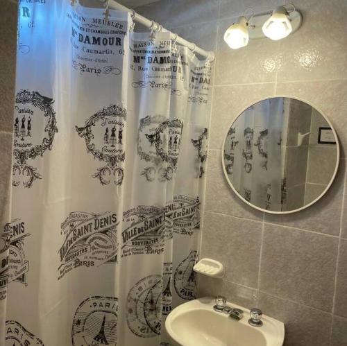 a bathroom with a shower curtain with a sink and a mirror at Grandioso Barrio Sur - 100mts de Casa Histórica in San Miguel de Tucumán
