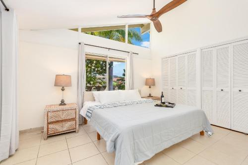 a white bedroom with a bed and a window at Tranquil Marina Front Pool House Resort in Honolulu