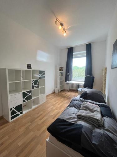 um quarto com uma cama, uma secretária e uma janela em Zwischen Stadt und Park em Bad Wildungen