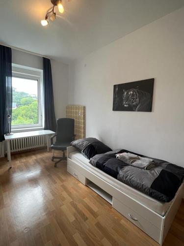 ein Schlafzimmer mit einem Bett, einem Stuhl und einem Fenster in der Unterkunft Zwischen Stadt und Park in Bad Wildungen
