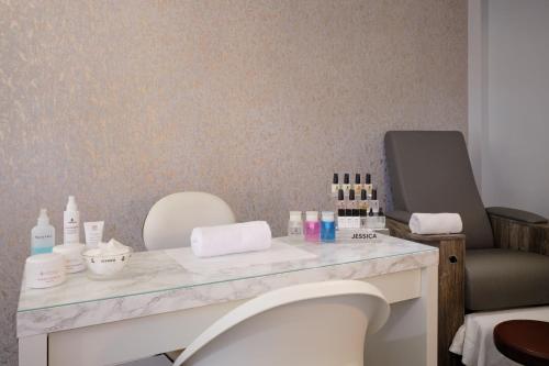 a bathroom with a vanity with a lot of cosmetics at Delta Hotels by Marriott Breadsall Priory Country Club in Derby