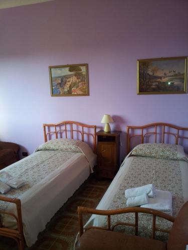 Habitación con 2 camas y una silla. en Le Giarette, en Cefalú