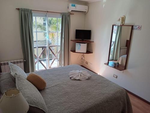 Schlafzimmer mit einem Bett mit einem Spiegel und einem Fenster in der Unterkunft Hotel Gran Lido in Santa Teresita