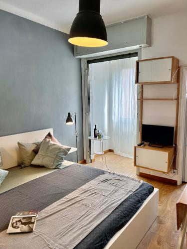 ein Schlafzimmer mit einem großen Bett und einem großen Fenster in der Unterkunft Cozy Apartment 3 km away from Duomo in Mailand