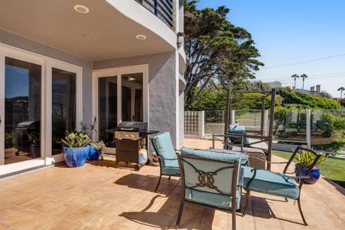 a patio with chairs and a grill in a house at Luxury in Malibu in Malibu