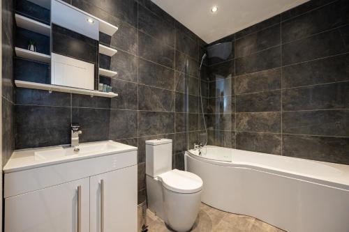 a bathroom with a toilet and a tub and a sink at Luxury 2 Bedroom Apartment In Chorlton in Manchester