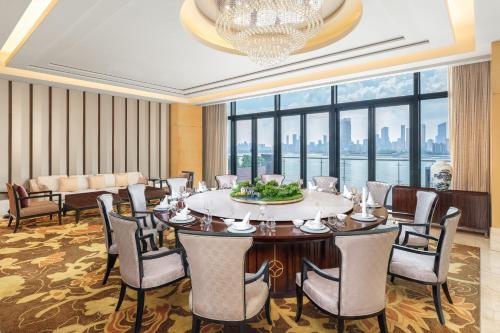 a dining room with a table and chairs and a chandelier at The Westin Wuhan Wuchang in Wuhan