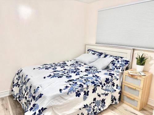 - une chambre avec un lit orné de fleurs bleues dans l'établissement Master Bedroom with Full Washroom, free wi-fi, free Parking near Fairview Park Mall ROOM 3, à Kitchener