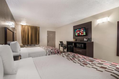 a hotel room with two beds and a flat screen tv at Red Roof Inn Crossville in Crossville