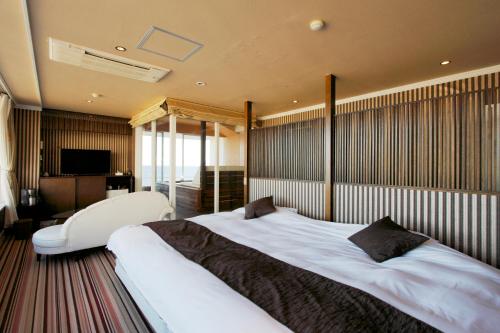 a bedroom with a large bed and a television at Atagawa Yamatokan in Higashiizu