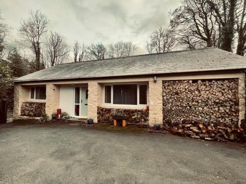 a brick house with a stone wall at Beautiful renovated former coach house in Llandeilo