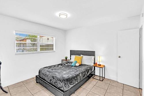 1 dormitorio con cama y pared blanca en Modern 2br Oasis Mins To Beach & Casino Db2, en Dania Beach