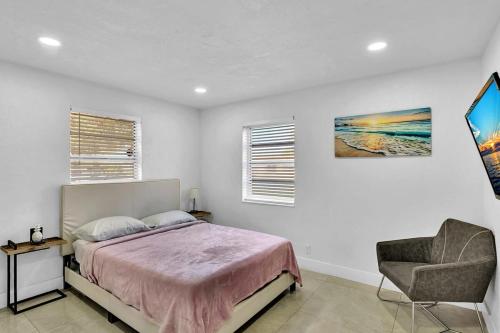 a bedroom with a bed and a chair at 2 Bdrm Modern House Mins From Beach & Casino Hb1 in Hallandale Beach