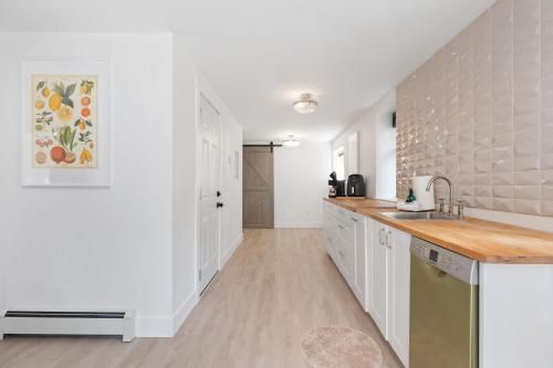a kitchen with white cabinets and a counter top at Carrington Chateau in Vancouver